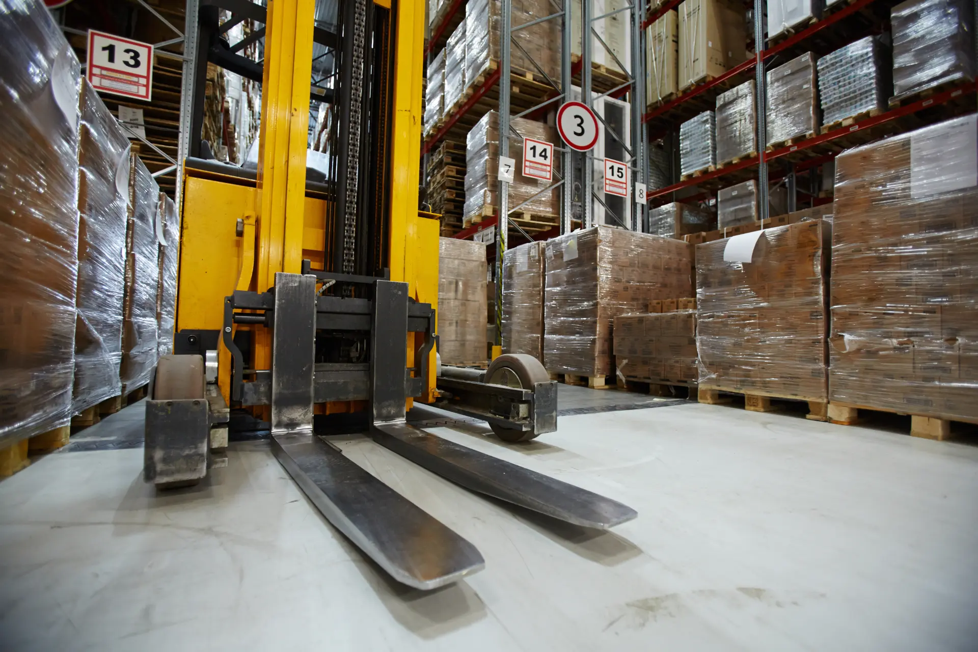 Forklift truck in a warehouse aisle