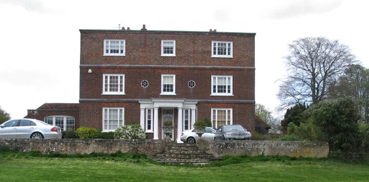 Three storey Georgian red brick house with a walled front garden