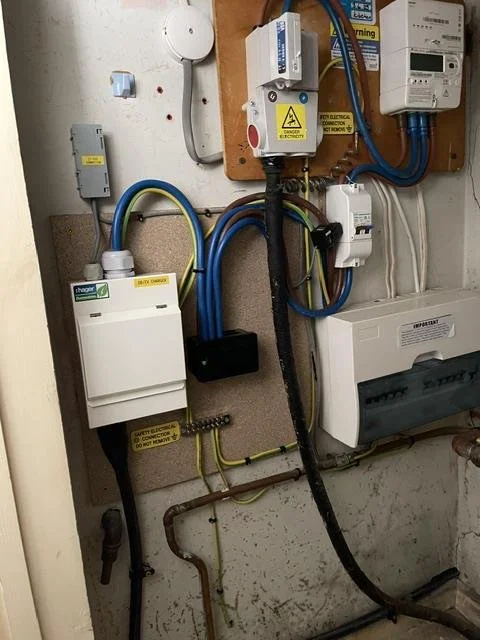 Electricity meter with new isolator and protective devices fitted on a wooden board
