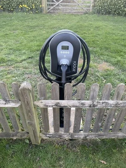 Wallbox mounted on a post beside a garden fence