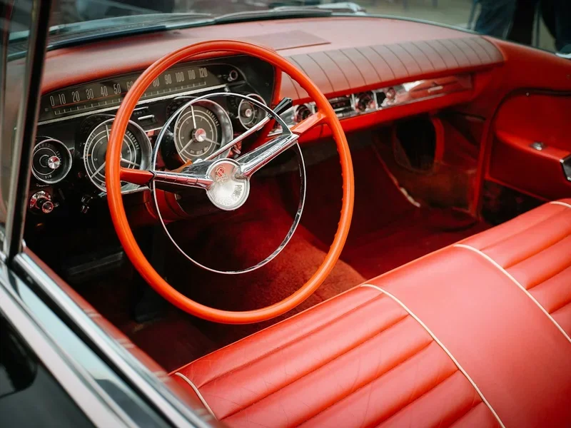 Red bench seat and steering wheel in a vintage car