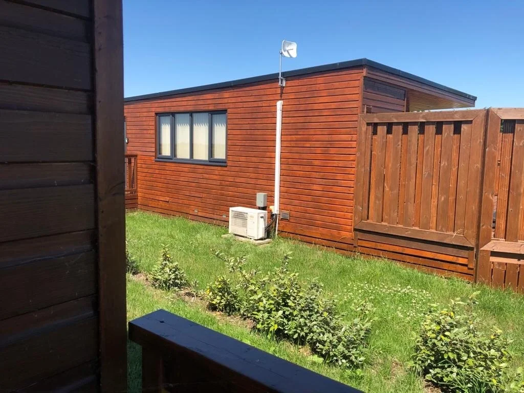 Air conditioning outdoor unit beside a timber building