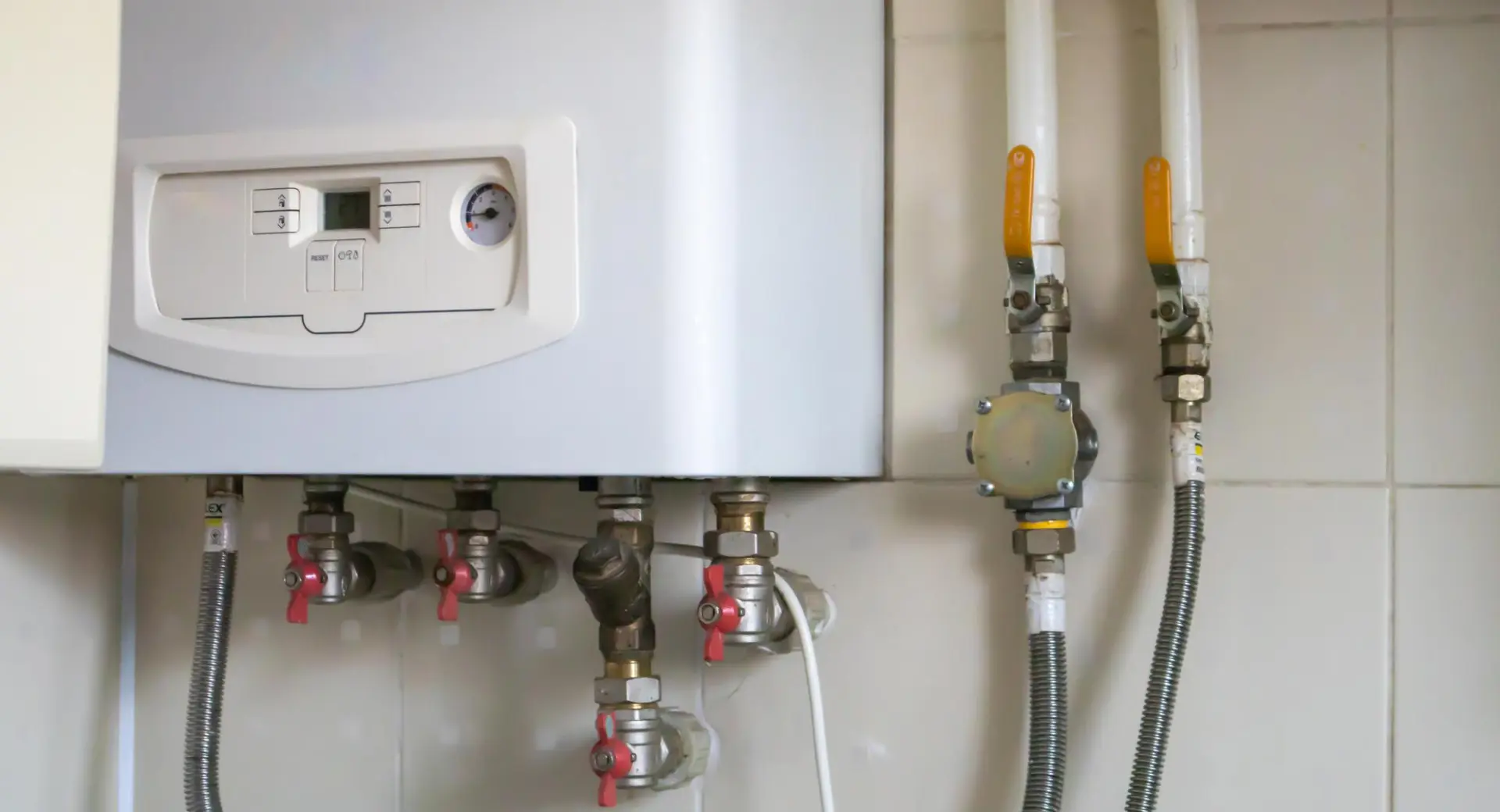 White boiler with visible controls and gas pipework