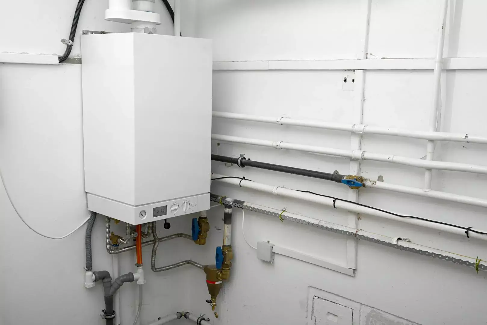 White boiler with visible gas and heating pipework