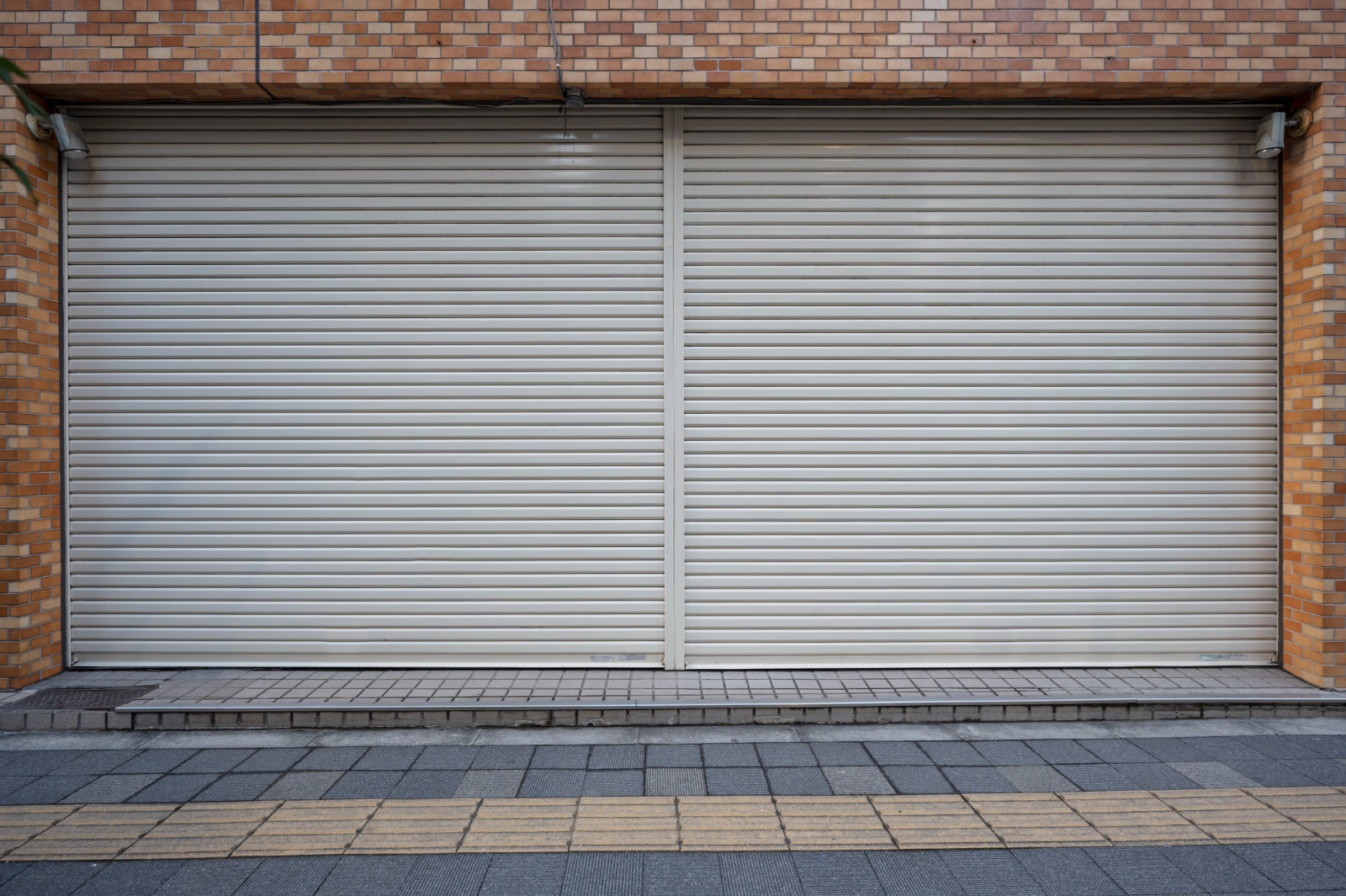 Roller Shutter On White Property - How Do Security Shutters Protect A Business