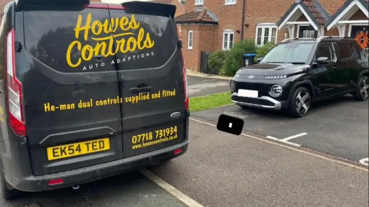 The Howes Controls van parked at a customer address beside their car