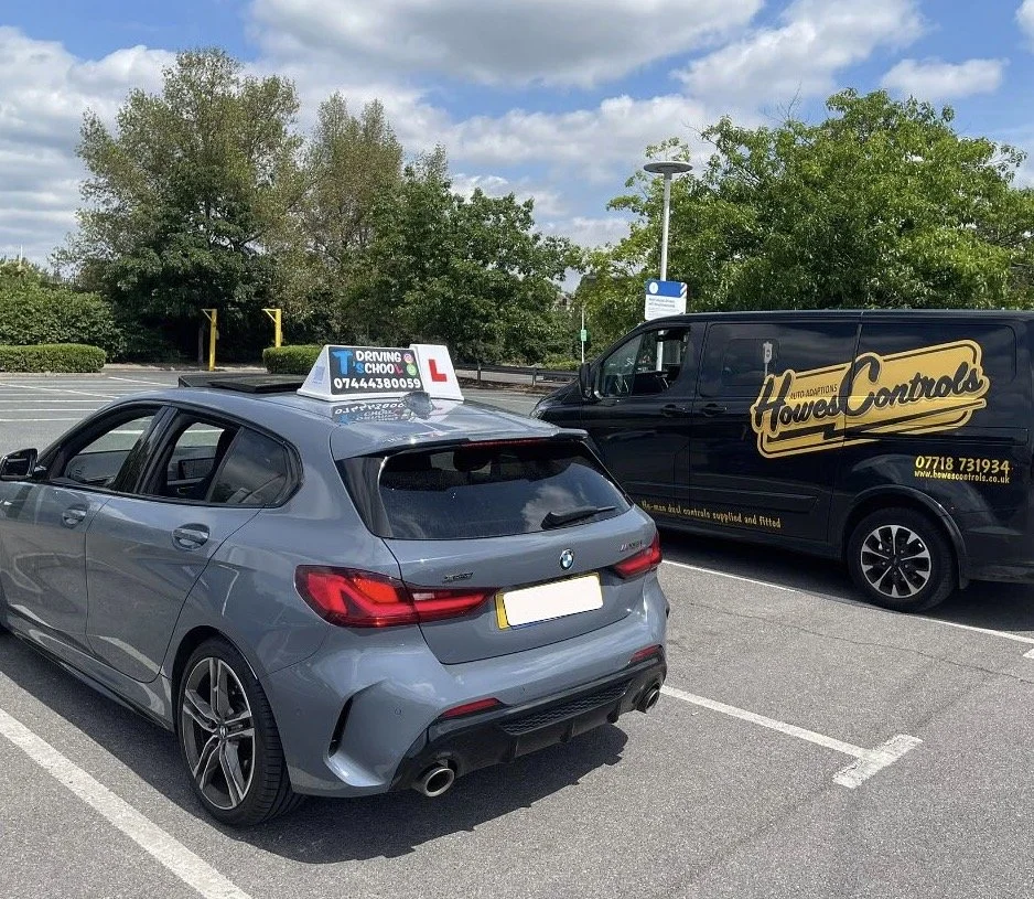 Howes Controls mobile fitting van beside a driving school car